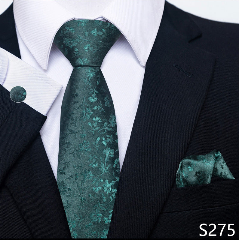 Teal patterned tie and pocket square set with a black suit and white shirt.