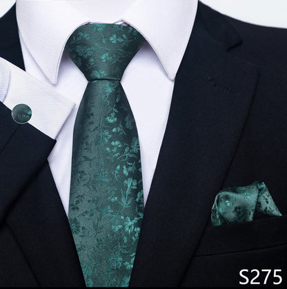 Teal patterned tie and pocket square set with a black suit and white shirt.