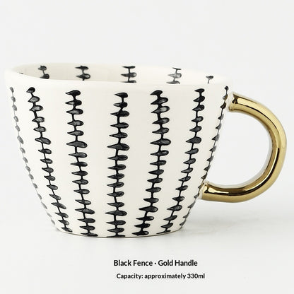 White mug with black wavy pattern and gold handle on a white background