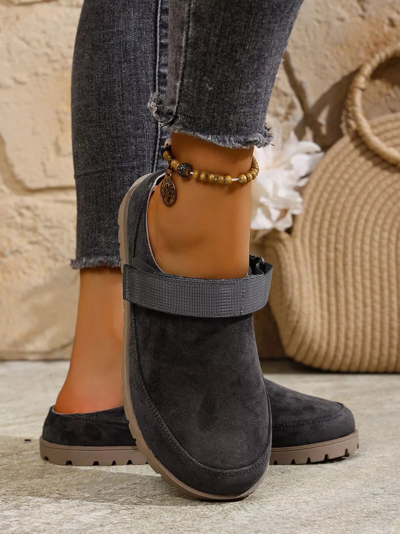 Dark gray round-toe slip-on flats with side strap and low profile tread sole