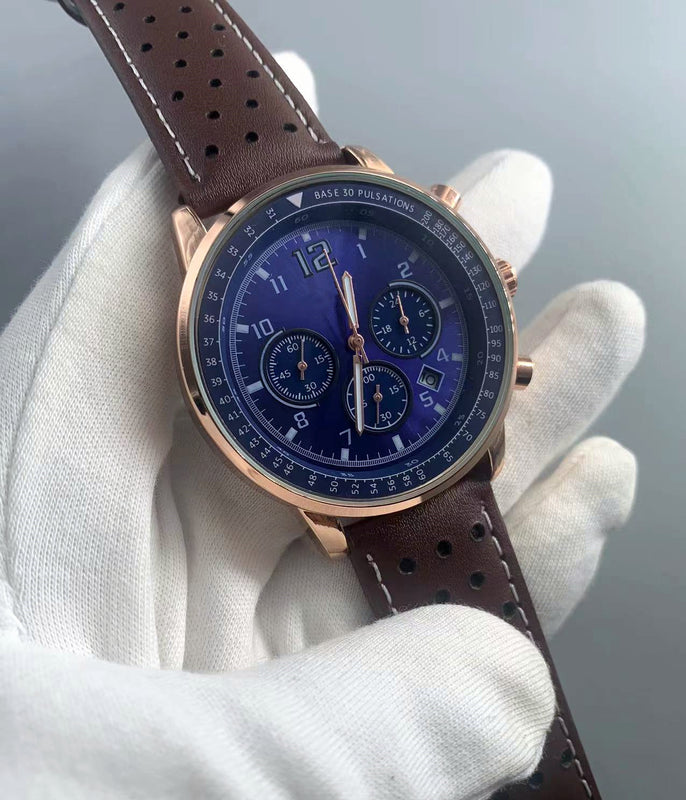 Rose-gold-tone quartz watch with blue dial and perforated brown strap held in a gloved hand