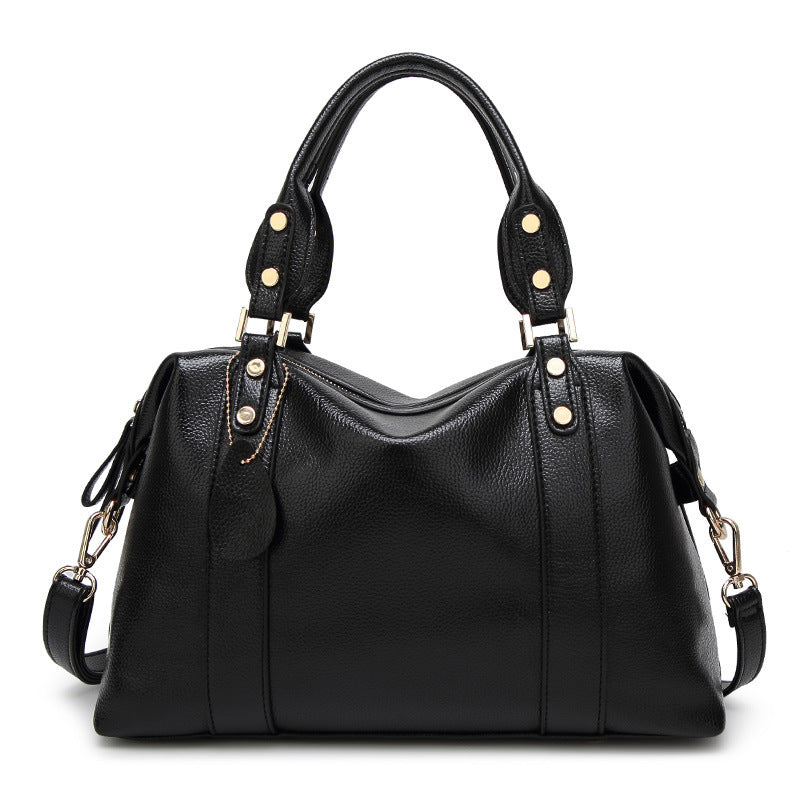 Black handbag with gold accents on a white background