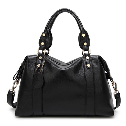 Black handbag with gold accents on a white background