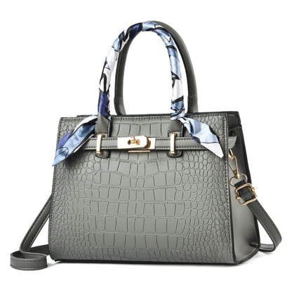 Gray textured handbag with a decorative scarf on a white background