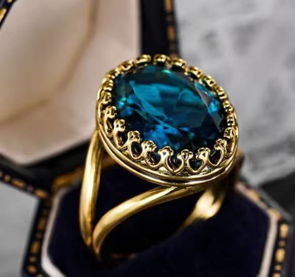 Gold ring with a blue gemstone on a dark background