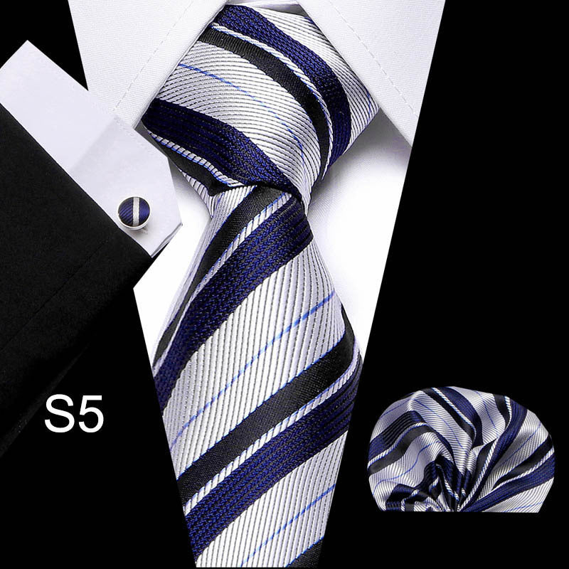 Striped tie with matching pocket square and cufflinks on a black background