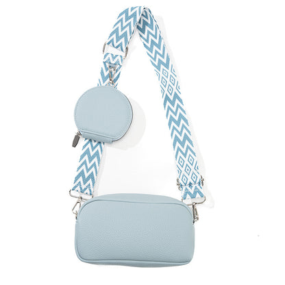 Light blue crossbody bag with a patterned strap on a white background