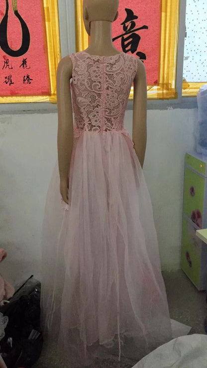 Mannequin wearing a pink lace dress in a room with a yellow wall and text.