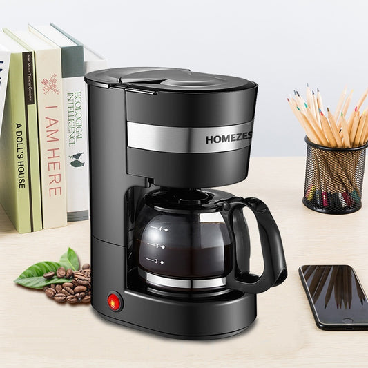 Black coffee maker with 'HOMEZEE' branding on a desk with books, pencils, and a phone.