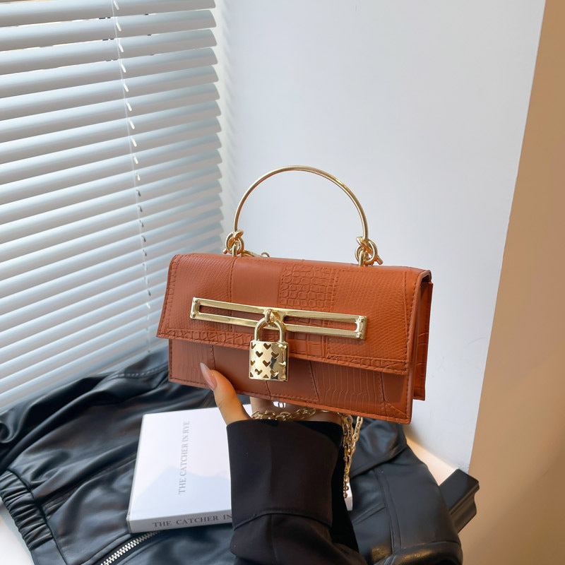 Women’s chain crossbody bag in orange PU leather with gold-tone clasp bar and chain