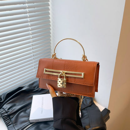 Women’s chain crossbody bag in orange PU leather with gold-tone clasp bar and chain