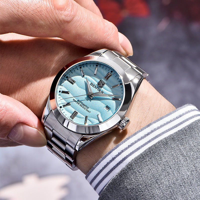 Close-up of a hand wearing a silver wristwatch with a blue face.