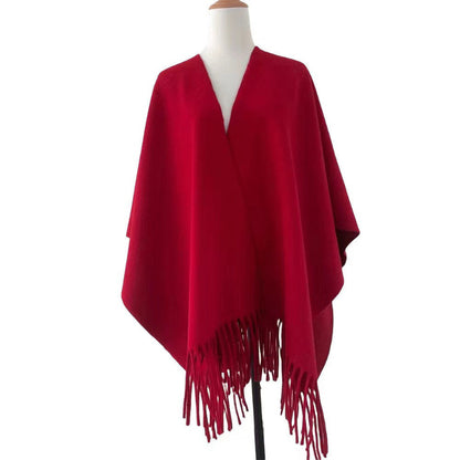 Red poncho with fringes on a mannequin against a white background