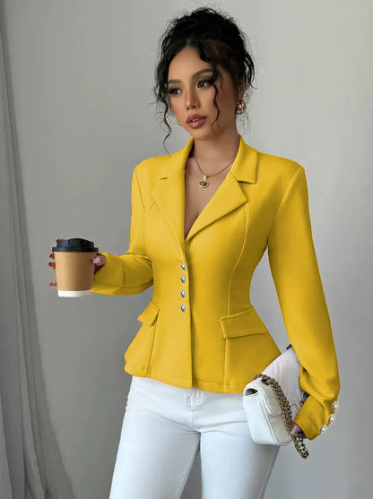 Woman wearing a yellow blazer holding a coffee cup and white handbag against a plain background