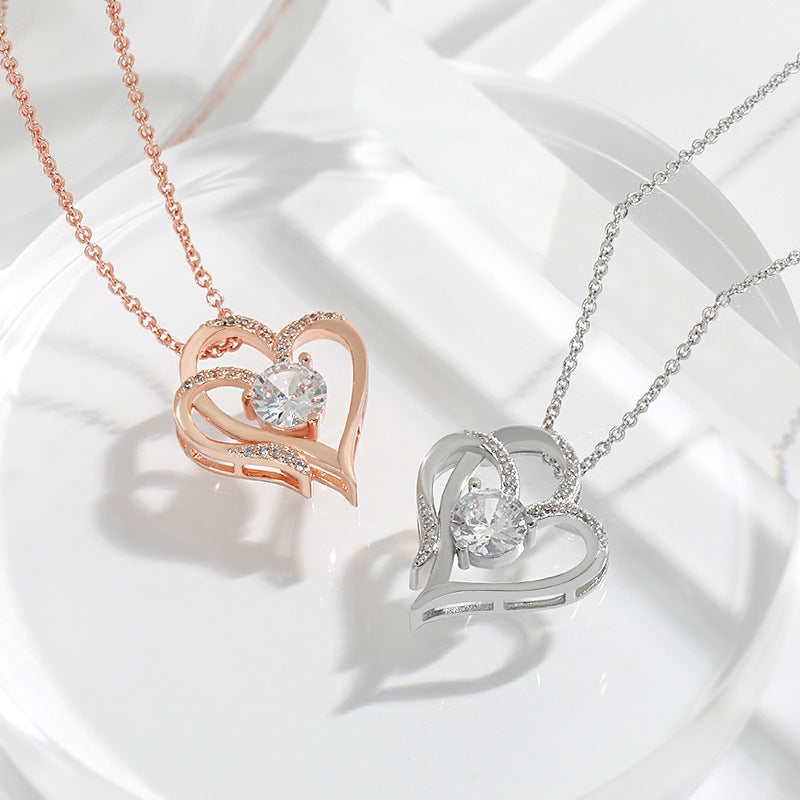 Two heart-shaped pendants, one rose gold and one silver, on white background