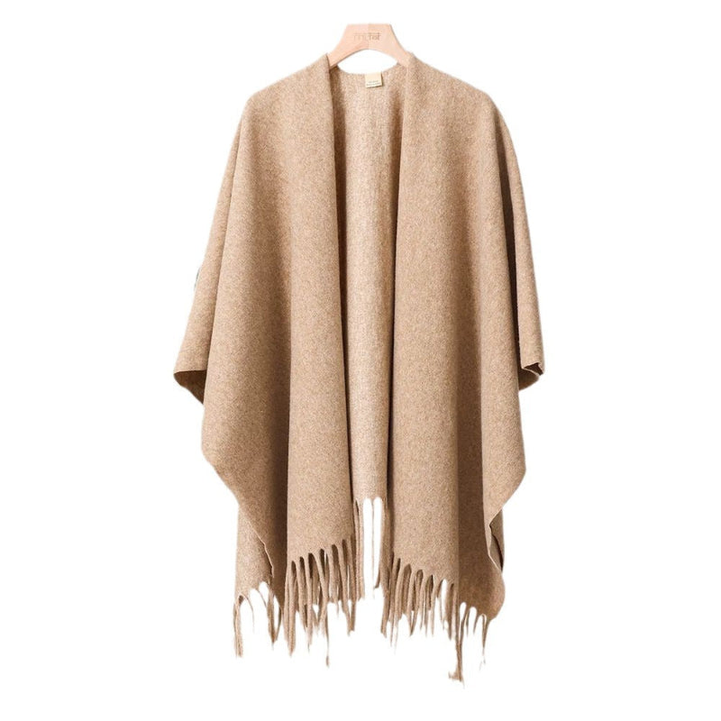 Beige poncho with fringe details on a white background