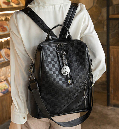 Women’s PU leather backpack, black checkered pattern with front zipper and charm pendant