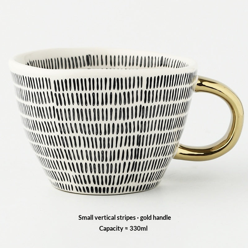 White mug with black vertical stripes and gold handle on a white background