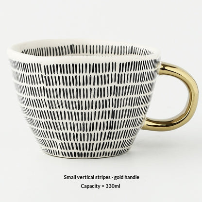 White mug with black vertical stripes and gold handle on a white background