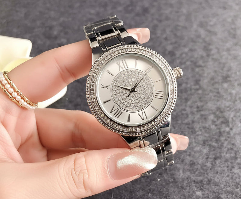 Silver Guess watch held in a hand with a Guess box in the background