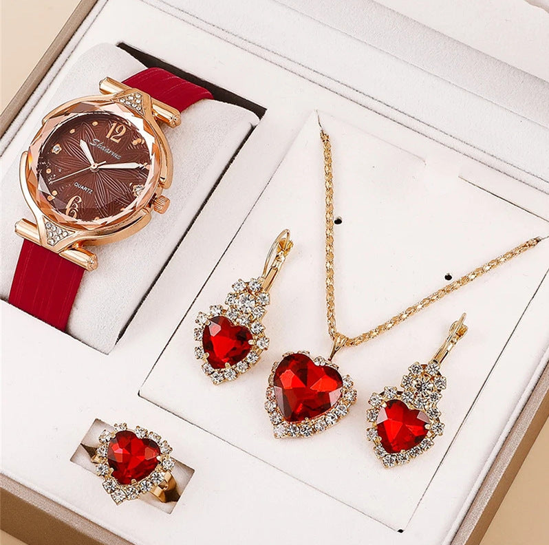 Jewelry set with red heart-shaped stones including a watch, necklace, and earrings on a white background.