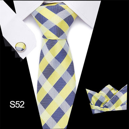 Plaid tie set with matching cufflinks and pocket square on a white shirt.