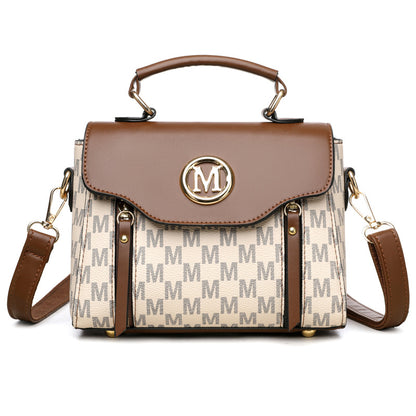 Handbag with brown leather top handle and beige body with 'M' pattern on a white background