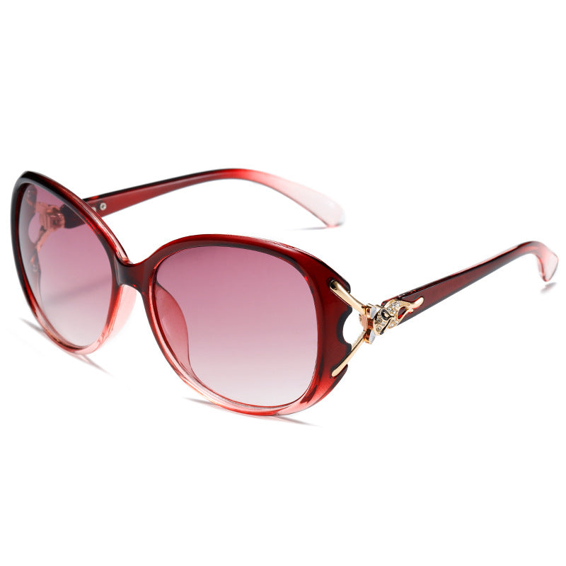 Oversized cat-eye sunglasses, red frame with rose-pink gradient lenses and gold fox ornament