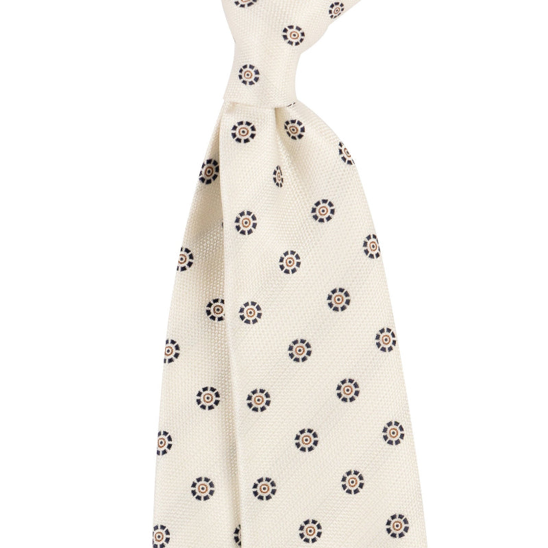 White knotted tie with black and brown floral pattern on a white background