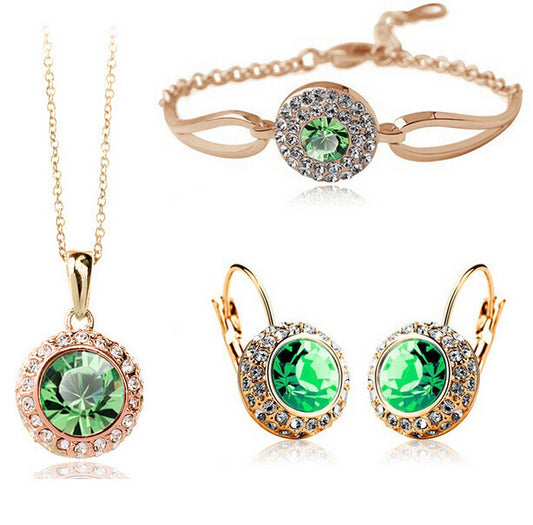 Jewelry set with green gemstones including necklace, bracelet, and earrings on a white background