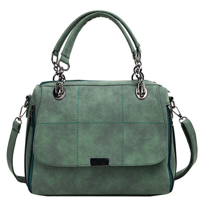 Large green matte shoulder bag with front flap and stitched panels, ring handles, crossbody strap