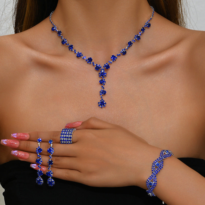 Blue gemstone necklace, ring, and bracelet set on a model with a neutral background