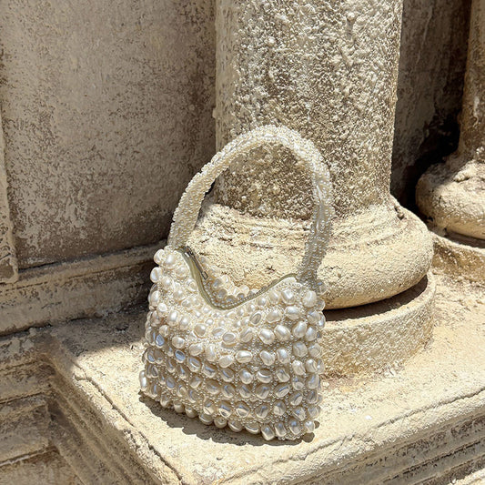 White pearl-beaded mini handbag with top handle, woven bead pattern and scalloped edges