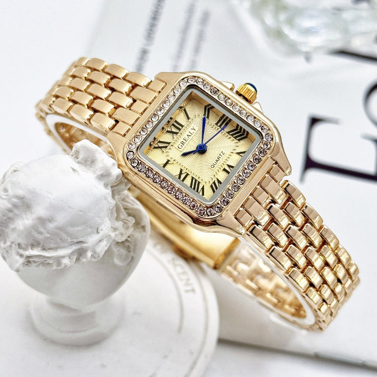 Gold wristwatch with diamond accents on a white surface