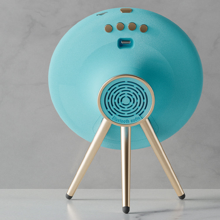 Turquoise Bluetooth speaker with gold legs on a gray background