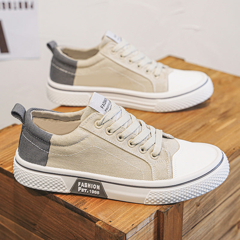 Beige and gray sneakers on a wooden surface with a blurred background