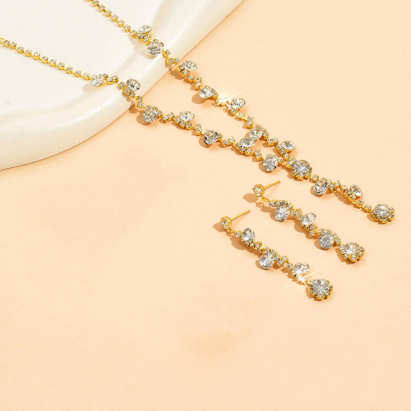 Gold necklace and earrings on a beige background