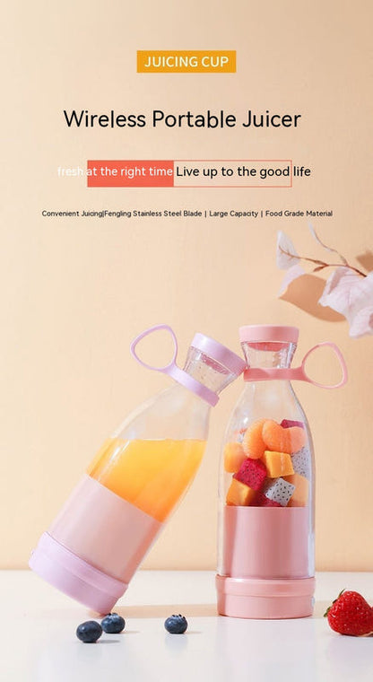 Pink portable juicer with two blending bottles and fruit pieces in the cups