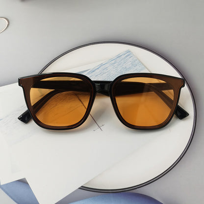 Brown sunglasses with yellow-tinted lenses on a white surface