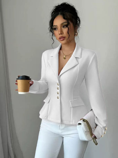 Woman in a white blazer holding a coffee cup against a plain background