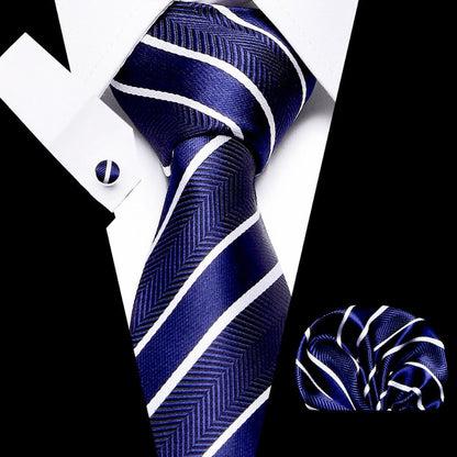 Navy blue tie with white stripes, cufflinks, and pocket square on a black and white background