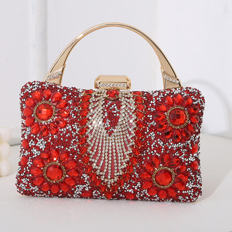 Red beaded handbag with gold accents on a white background