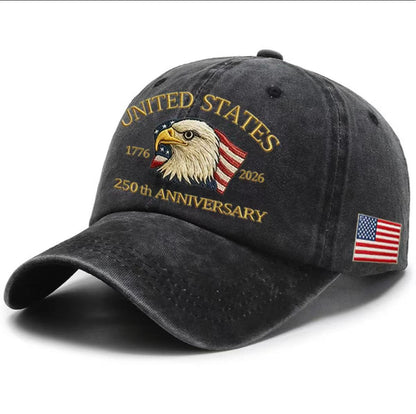 Charcoal gray washed-print cap with gold “United States 1776–2026” eagle graphic and flag patch.