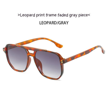 Sunglasses with leopard print frame and gray gradient lenses on a white background