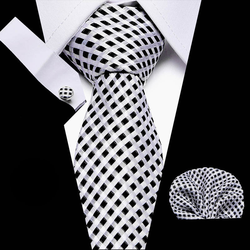 Black and white checkered tie with matching pocket square and cufflinks on a white background