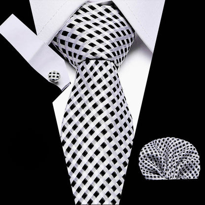 Black and white checkered tie with matching pocket square and cufflinks on a white background