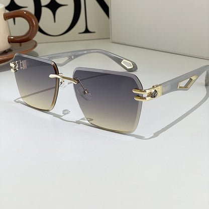 Sunglasses with gold frame and gradient lenses on a light surface