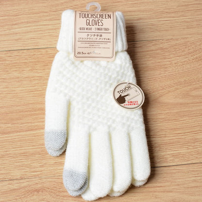White touchscreen gloves with a label on a wooden surface