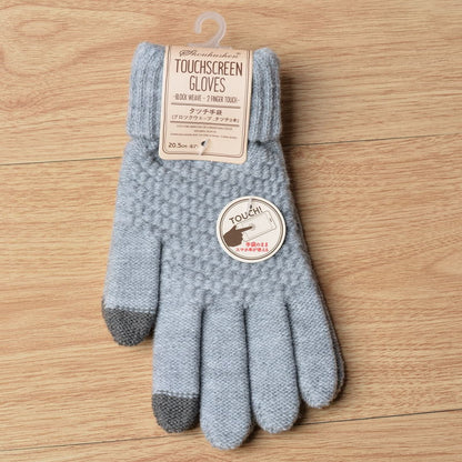 Gray touchscreen gloves with a label on a wooden surface