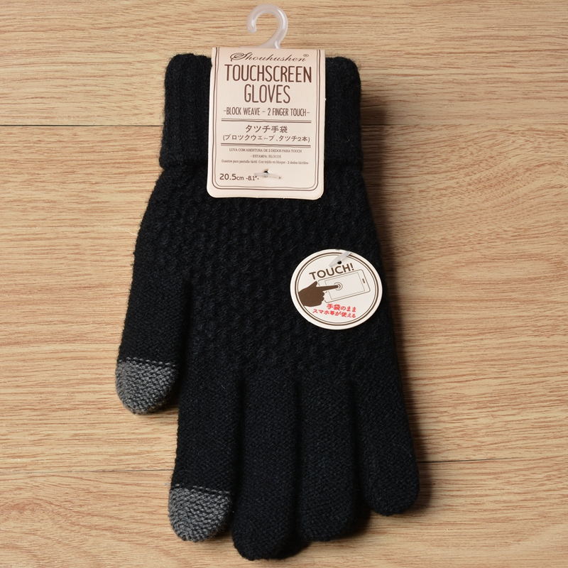 Black touchscreen gloves with a label on a wooden surface